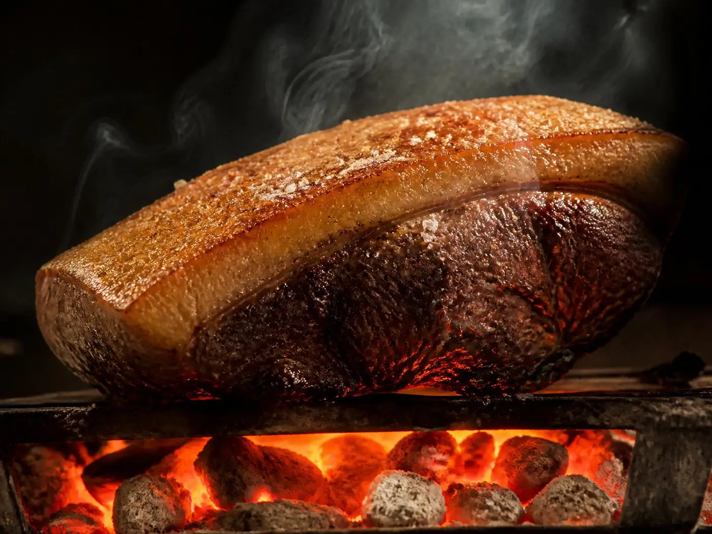 Picanha suculenta sendo assada sobre brasa